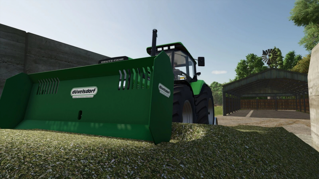 Düvelsdorf Silage Pack mod in FS25, featuring a green silage shield attached to a tractor near a barn.