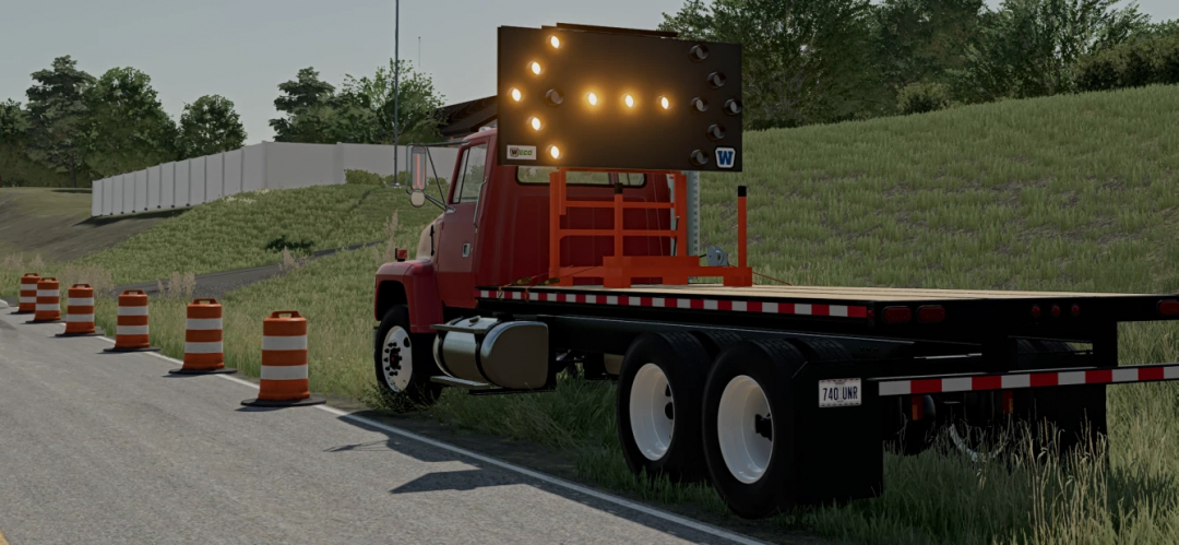 FS25 mod image showing a red truck with portable construction signs and traffic cones on a roadside.