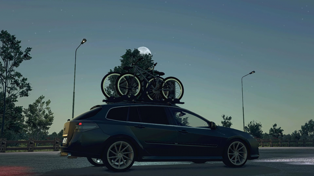 Renault Laguna III ph.2 Grandtour mod in FS25 with bikes on roof under night sky.