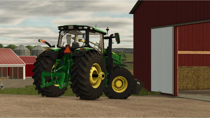 fs25-mods,  FS25 mod John Deere 6R US Large Frame tractor near a barn, showcasing its large tires and green frame.