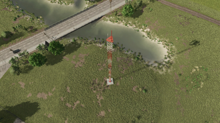 fs25-mods,  Aerial view of a radio tower mod in Farming Simulator 25, surrounded by grass and near a road and water.