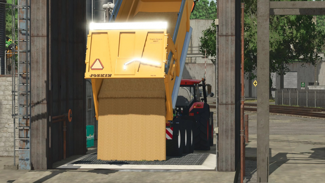 FS25 mod: Joskin TransSpace 8000 v1.0.0.0 trailer unloading grain at a facility in Farming Simulator 25.