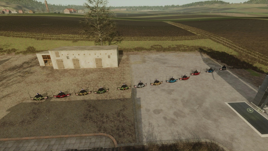 FS25 Multi brand bumpers mod v1.0.0.0 displayed on a farmyard, showcasing colorful attachments.