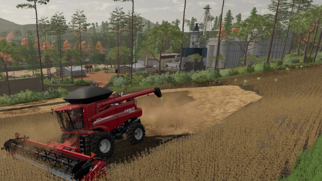 FS22 Pertile Map v1.0.0.0 mod: Harvester in field, scenic forest and farm buildings in the background.