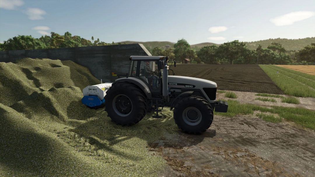 FS25 mod features WeberMT DSC 180 v1.0.0.0 attached to a tractor, compacting silage in a bunk at a farm.