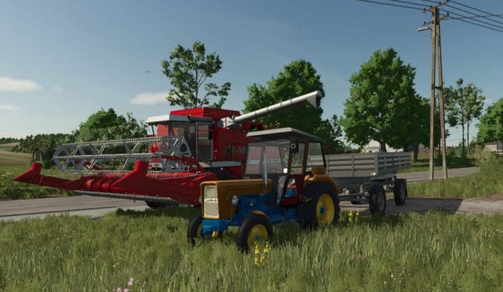 fs25-mods, FS25 Autosan pack v1.0.0.0 mod featuring a red harvester and blue tractor with trailer in a grassy field.