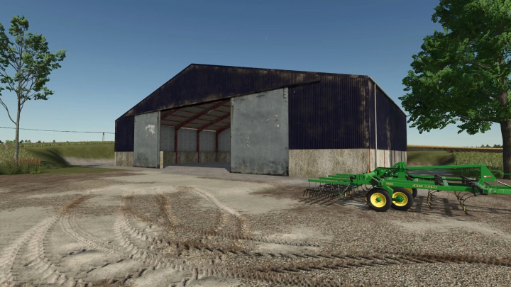 fs25-mods,  British Grain Sheds mod in FS25 showing a large barn with farming equipment nearby.