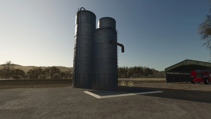 fs25-mods,  Low Cost Grain Silo mod for FS25 with three silos next to a barn in rural setting.