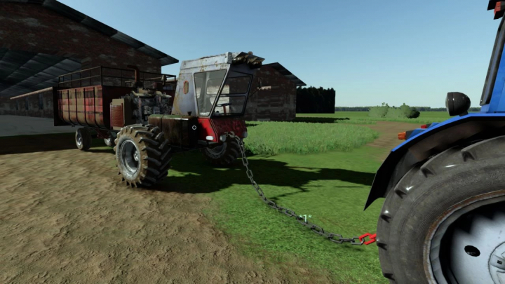 fs22-mods, FS22 mod NIVA SAMOPAL v1.0.0.0 showing a rusted agricultural vehicle chained to a blue tractor on a farm.