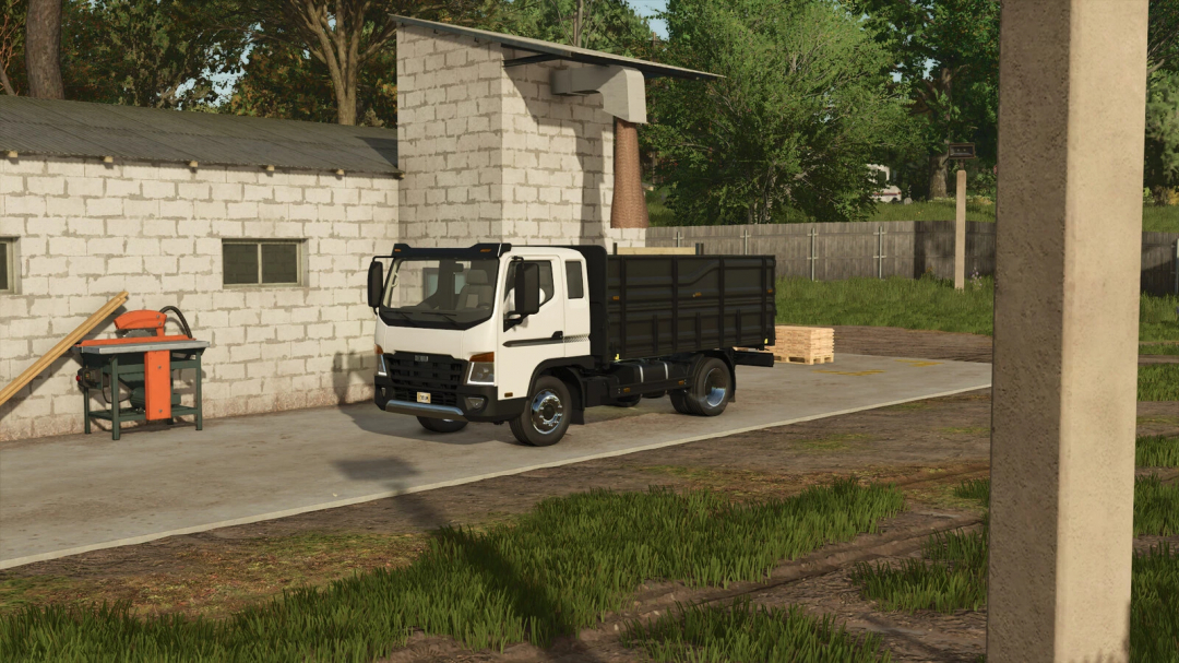 FS25 mod: Small sawmill with a parked white truck, wooden planks, and a saw machine, showcasing Farming Simulator 25 scenery.