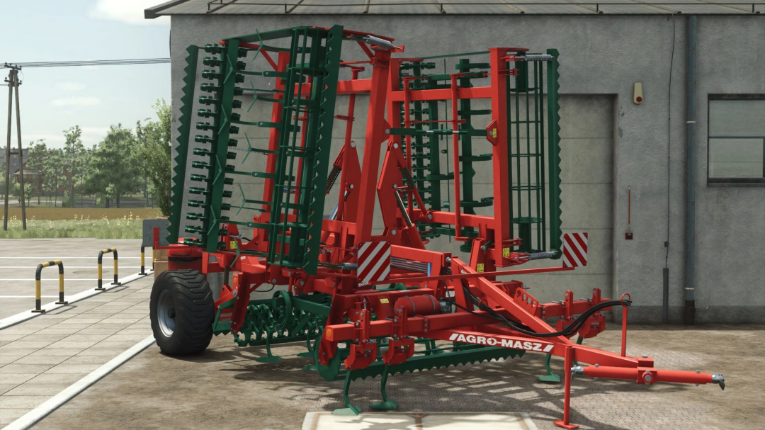 FS25 mod AgroMasz AUPC v1.0.0.0, a red and green cultivator, positioned outside a barn in Farming Simulator 25.