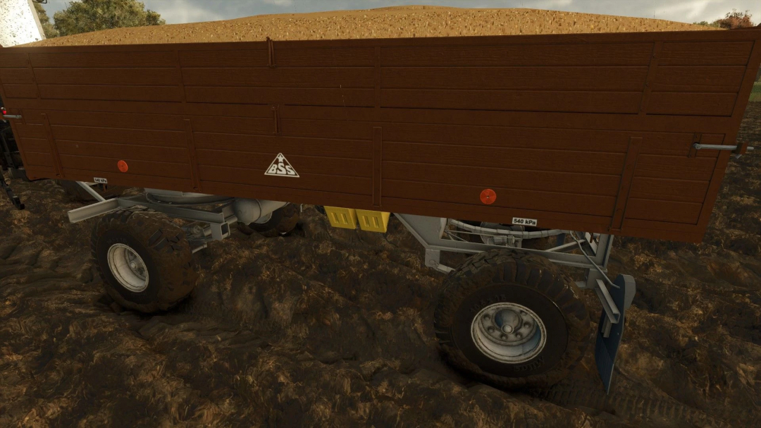 BSS P73SH trailer mod in FS25, featuring a brown wooden design on muddy terrain.