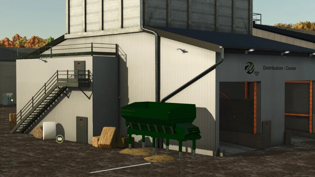 FS25 mod: DriveIn Distribution Center v1.0.0.0 exterior, featuring a central unloading point with equipment and storage area.