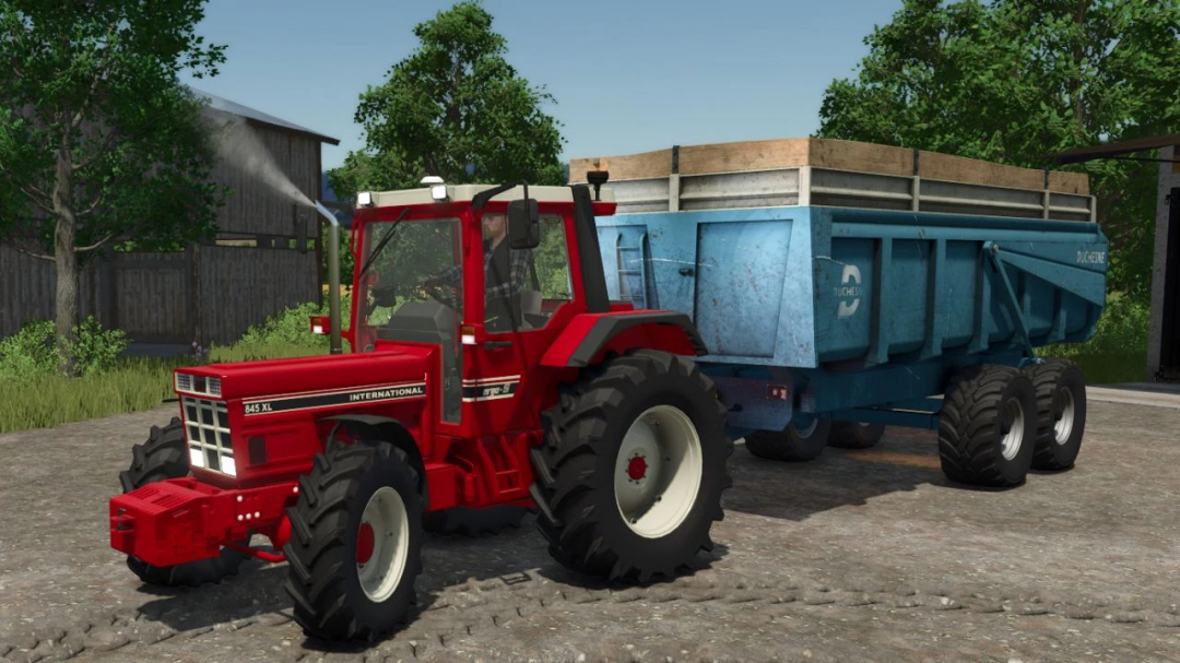 International IH 845XL tractor mod in FS25 with blue trailer on a farm.