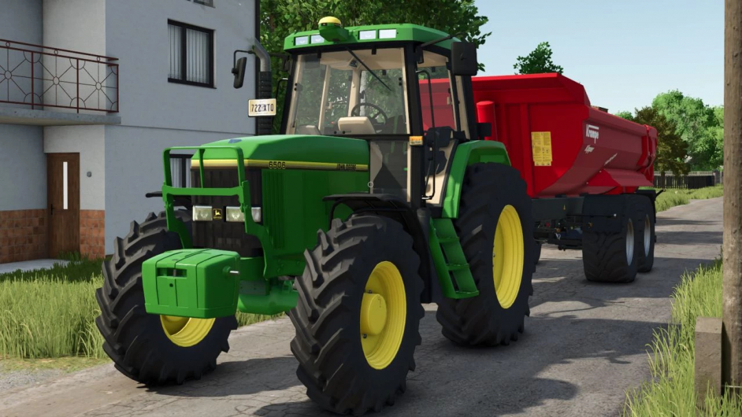 John Deere 6000 Series tractor mod in FS25 with red trailer on a farm road.