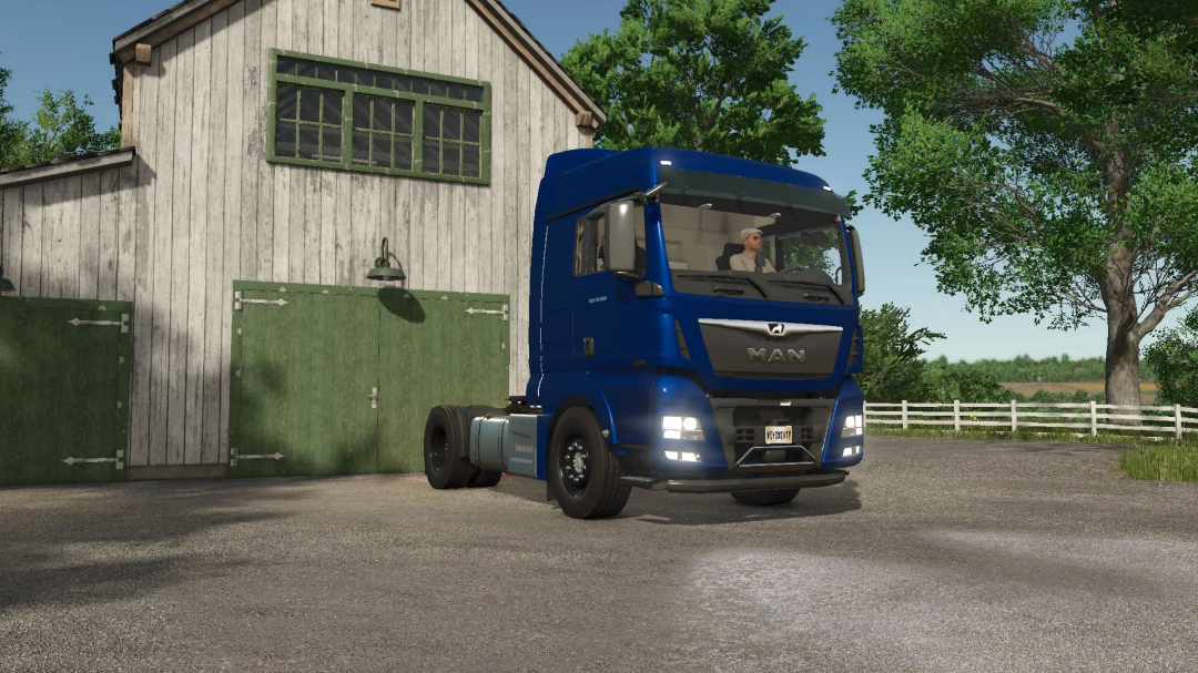 FS25 mod: MAN TGX 18500 truck in front of barn in Farming Simulator 25.