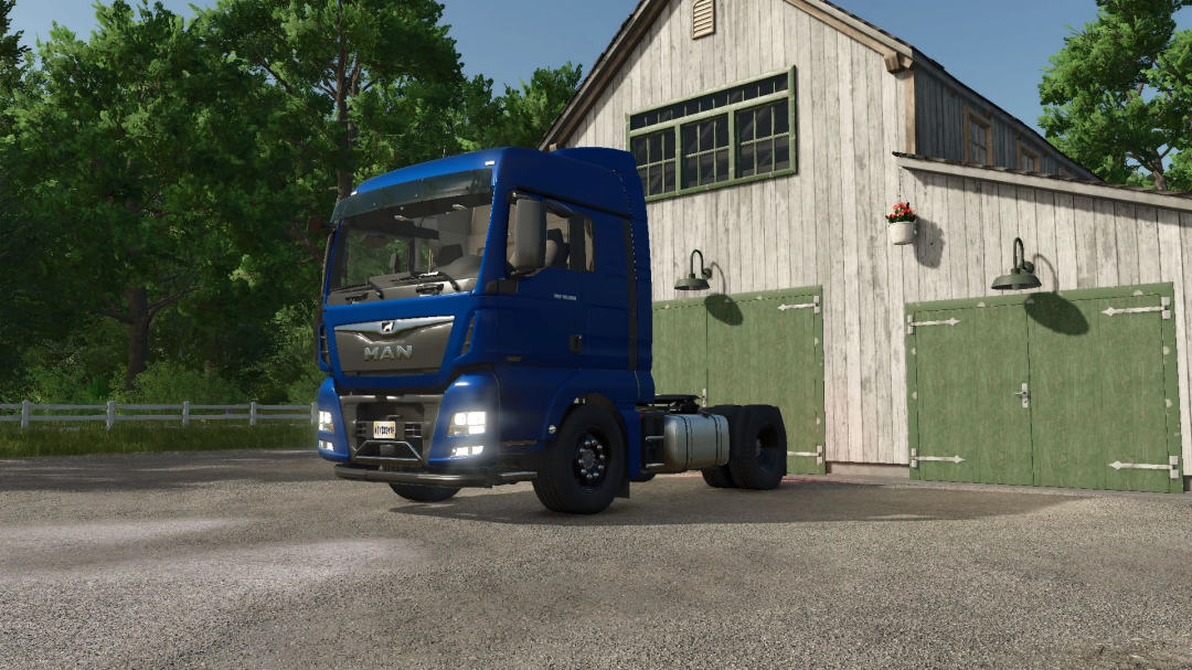 Blue MAN TGX 18500 truck parked in front of a barn in Farming Simulator 25 mod.