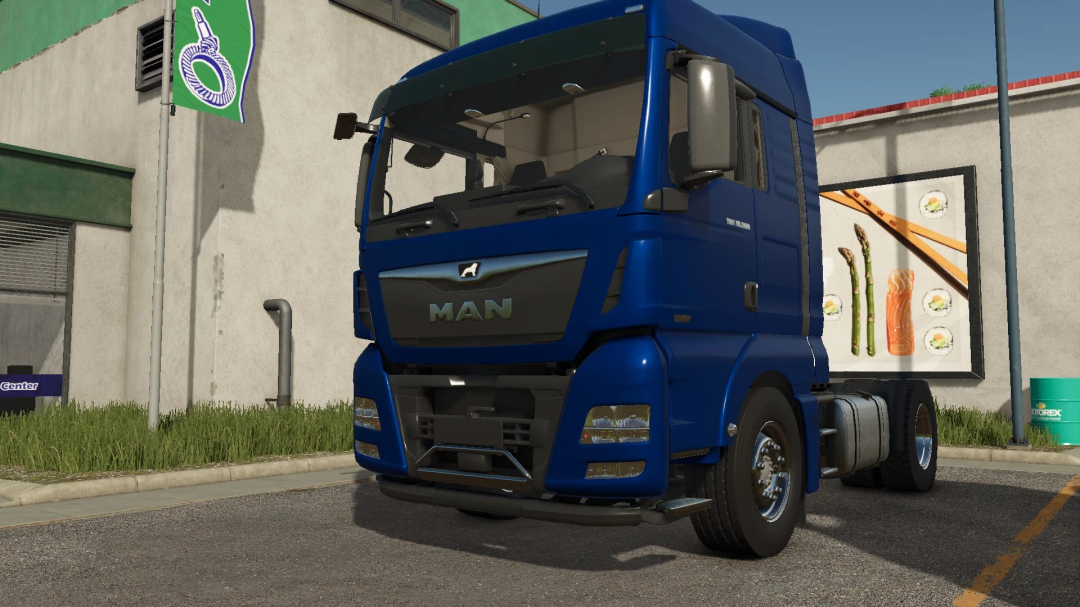 Blue MAN TGX 18500 truck mod in FS25, parked near a building with ads, enhancing Farming Simulator 25 gameplay.