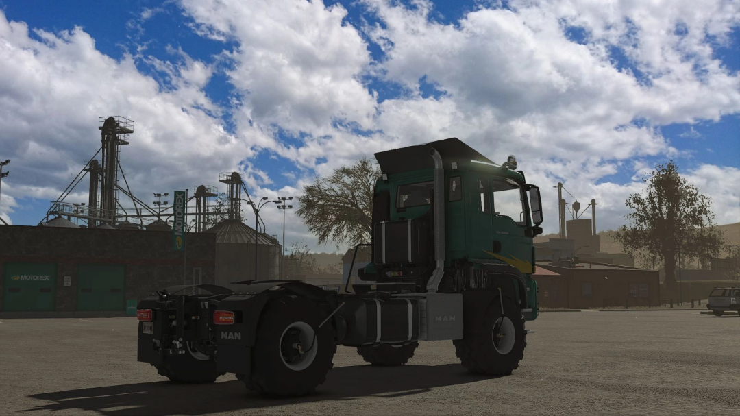 FS25 mod Man TGS AGRI v1.1.0.0 showcasing a truck in a farming industrial setting under cloudy skies.