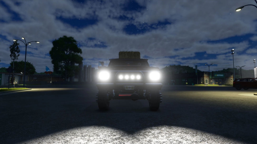 Front view of 78 Ford F350 mod at night in FS25 with headlights on.