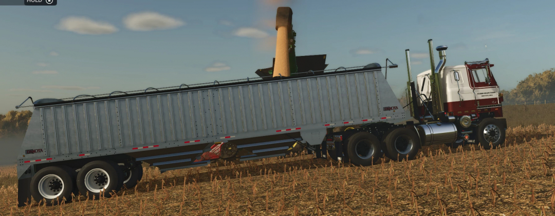 FS25 mod DM Dakota 38FT trailer in a field, showcasing Farming Simulator 25 gameplay.