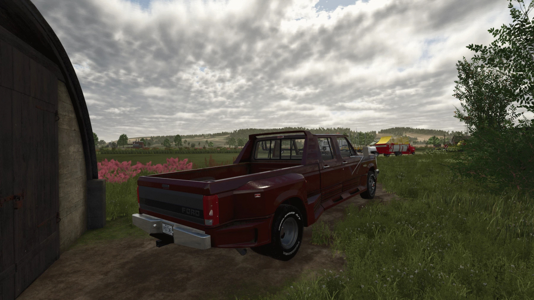 Ford OBS Truxarossa mod in FS25, parked near a barn with scenic farmland background.