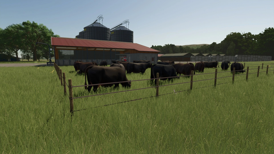 Cows grazing in a pasture near a barn in FS25 mod Legacy Township.