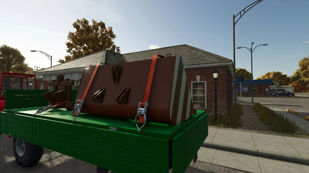 FS25 mod ZTS UN-053 Pack v1.0.0.1 featuring a brown weight attachment on a green trailer in a rural setting.