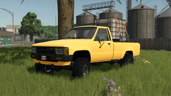 fs25-mods,  Yellow 1984 Toyota Hilux mod in Farming Simulator 25 next to silos.