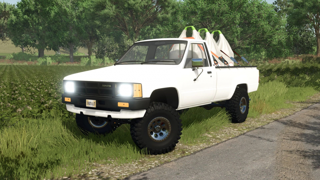 1984 Toyota Hilux mod in FS25, parked on a farm road with lush greenery.