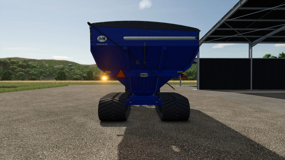 J&M X1112 Grain Cart Edit v1.0.0.0 mod in FS25, blue cart on asphalt with sunset