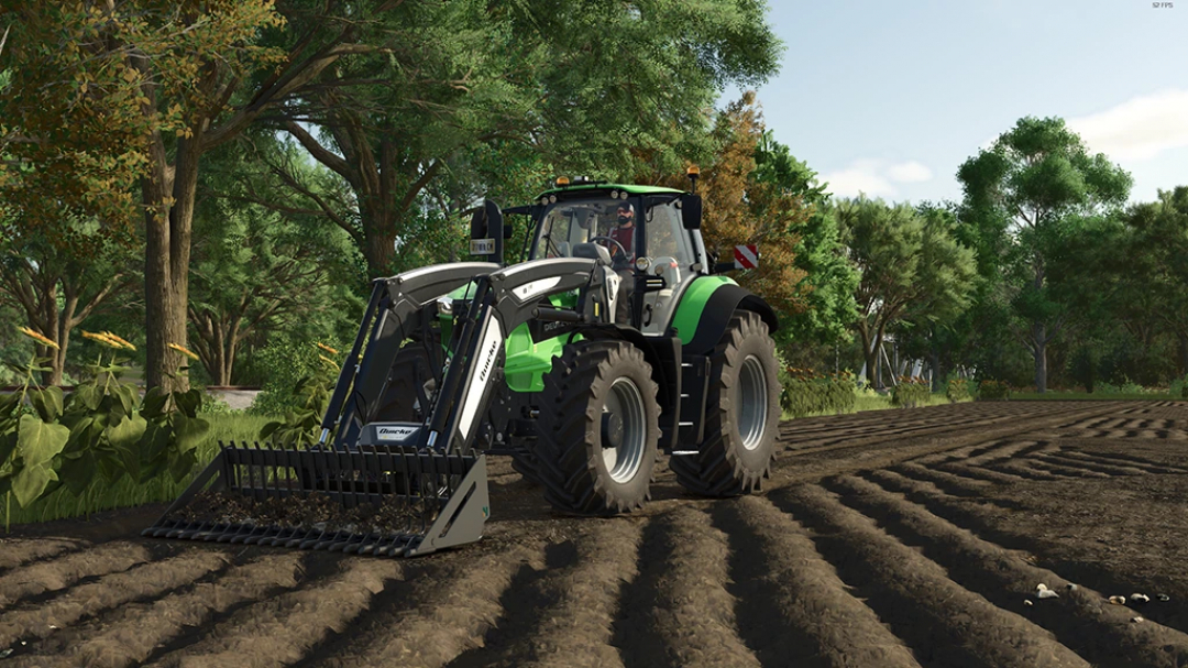 FS25 mods: Rockhound Stone Shovel v1.0.0.0 in a forest setting, showcasing a detailed shovel on a tractor in Farming Simulator 25.