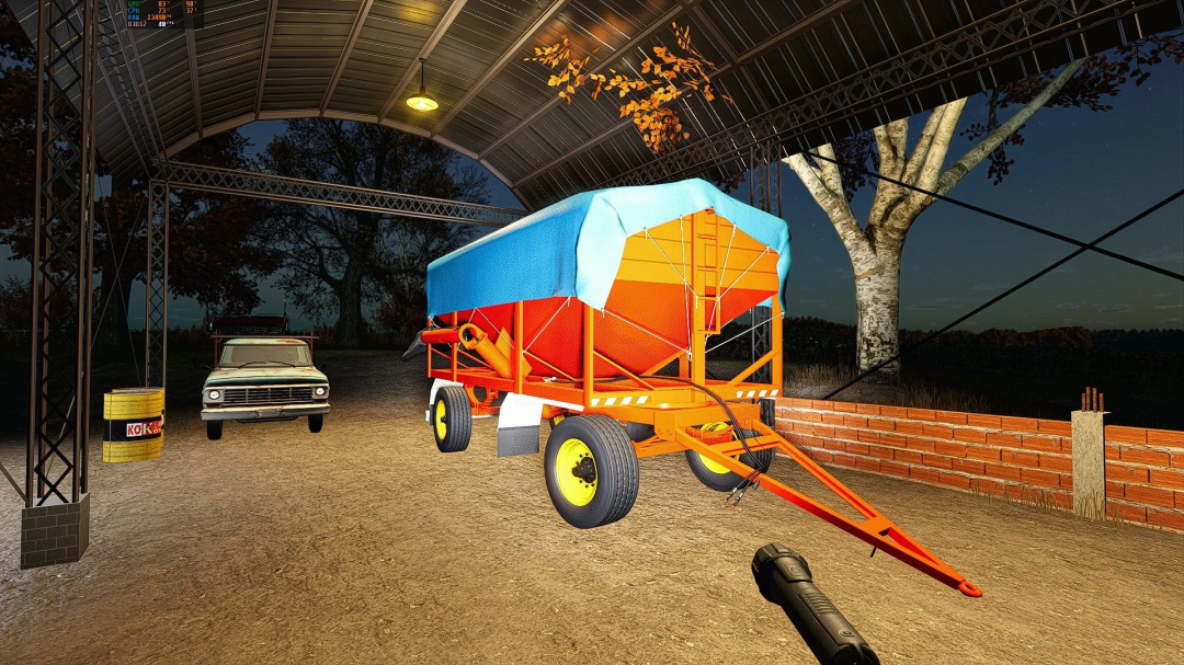 FS25 mods Tolva Vieja v1.0.0.0 in a garage at dusk, showcasing a bright orange trailer with a blue cover.