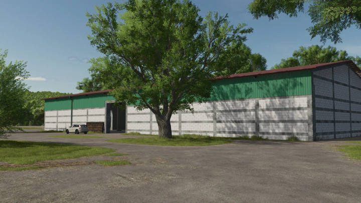 fs25-mods,  Large Warehouse mod in FS25, featuring a spacious building with green and gray exterior surrounded by trees.