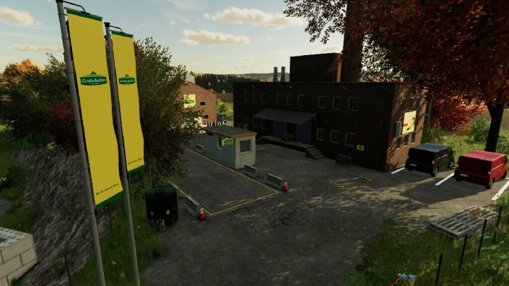 fs22-mods, FS22 mod The Eifel TerraLifePlus: industrial building with flags, parked vehicles, and trees in Farming Simulator 22.