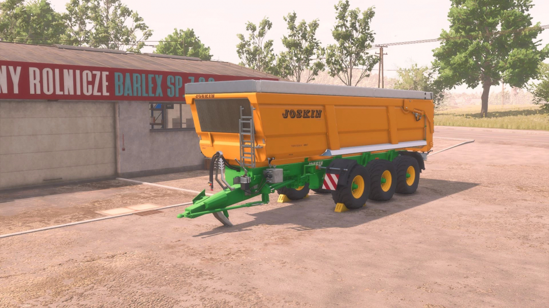 Image of Joskin TransSpace 8000 v2.0.0.0 FS25 mod, showcasing a yellow agricultural trailer parked beside a building.