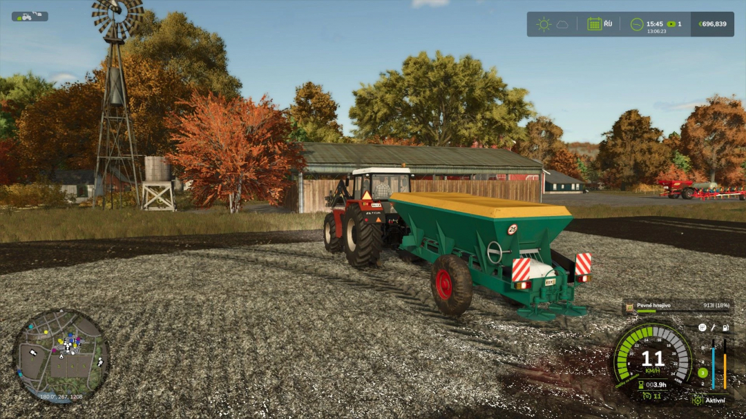 Tractor with Lizard RCW 5 mod in FS25, spreading fertilizer on a farm with autumn scenery.