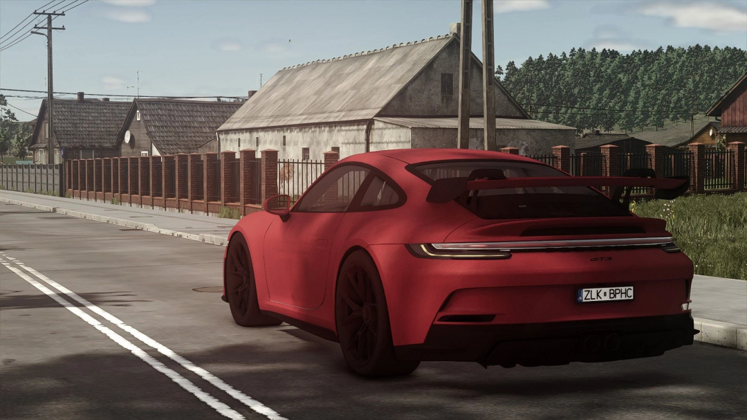 FS25 Porsche Carrera GT3 mod showcasing a red sports car on a rural road.