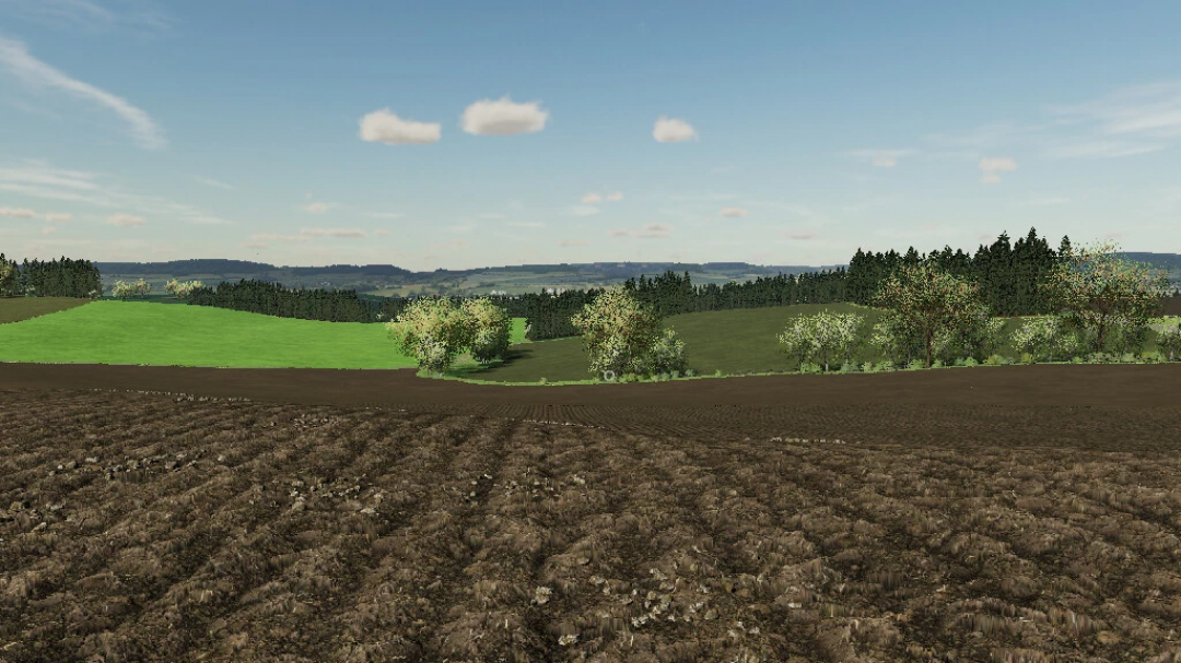 Scenic farmland landscape in FS22 mod The Eifel TerraLifePlus v1.2.0.0, featuring lush fields and distant hills.