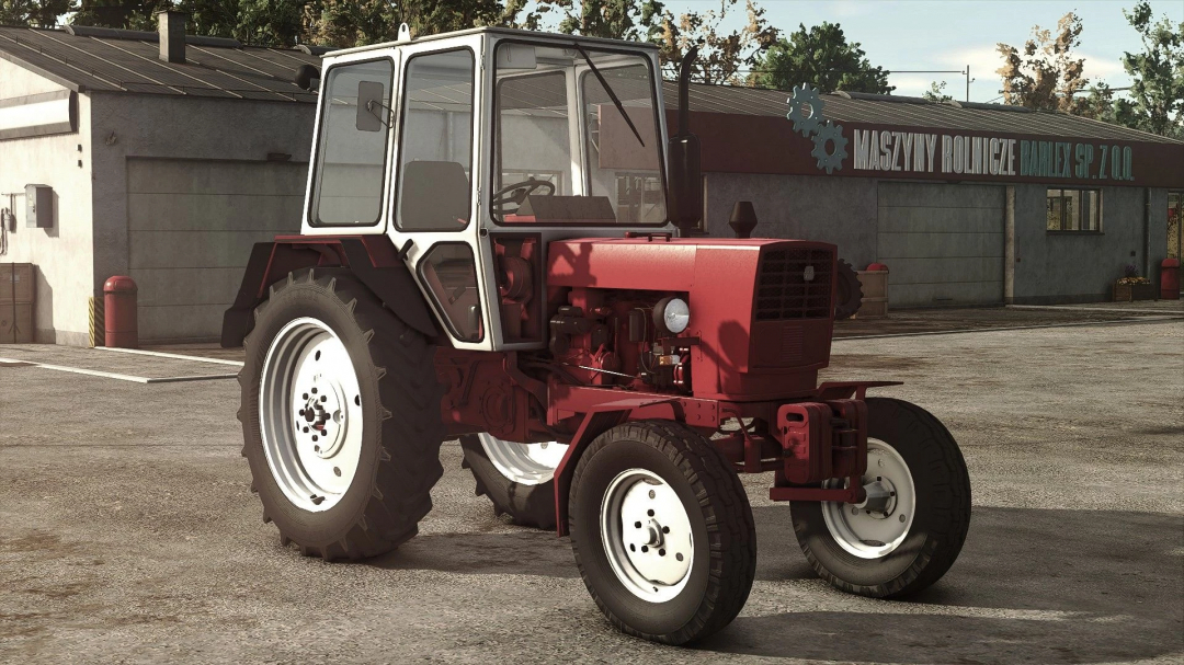 UMZ 6KL tractor mod for Farming Simulator 25 parked outside a barn.