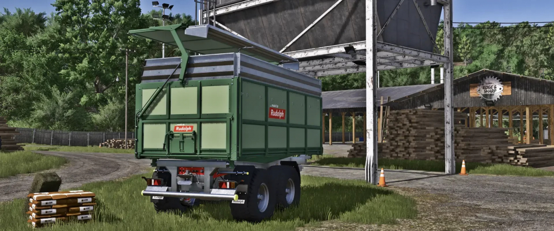 FS25 mod Rudolph TDK 301RA v1.0.3.0, a green agricultural trailer, parked near a sawmill in Farming Simulator 25.