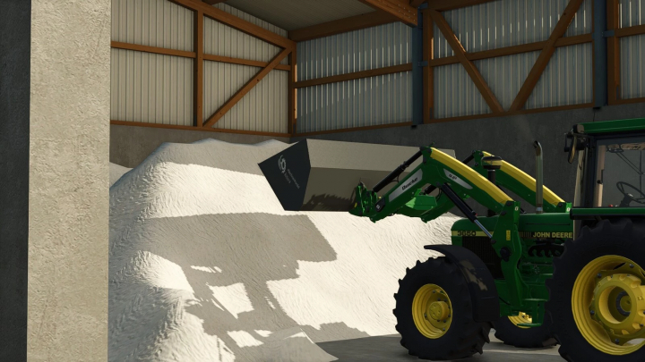 fs25-mods,  FS25 mod Roetterink Shovel Pack v1.0.0.0 in use with a green tractor in barn, lifting white material.