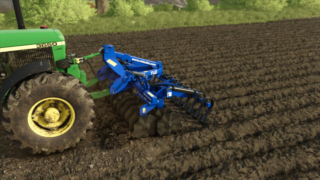 FS25 mod Rolmako Front Roller TwinDisc v1.0.0.0 attached to a tractor on a plowed field.