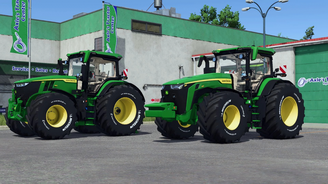 Two John Deere tractors with engraved Michelin tires parked at Axle's Tractor Center in FS25 mods.