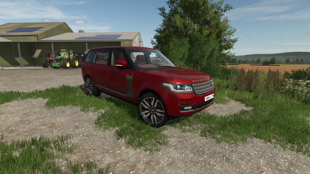 Red Range Rover LWB mod in FS25 parked by farm buildings and tractors.