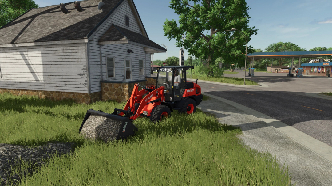 Farming Simulator 25 mod depicts a loader with gravel near a rustic house, showcasing the Tip Anywhere feature.