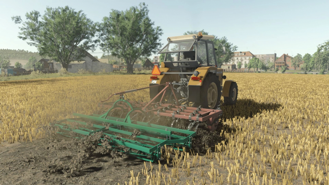 A tractor using the Bomet U725 mod in Farming Simulator 25, plowing a field with trees and buildings in the background.