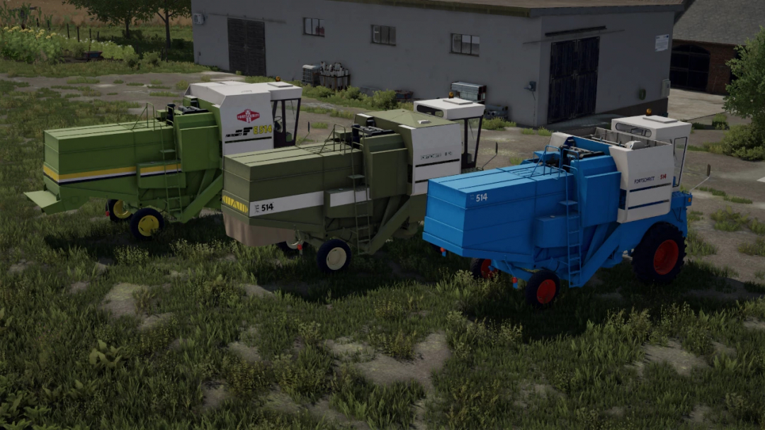 FS22 mods Fortschritt E512 & E514 showcasing three harvesters in different colors parked outside a building in Farming Simulator 22.