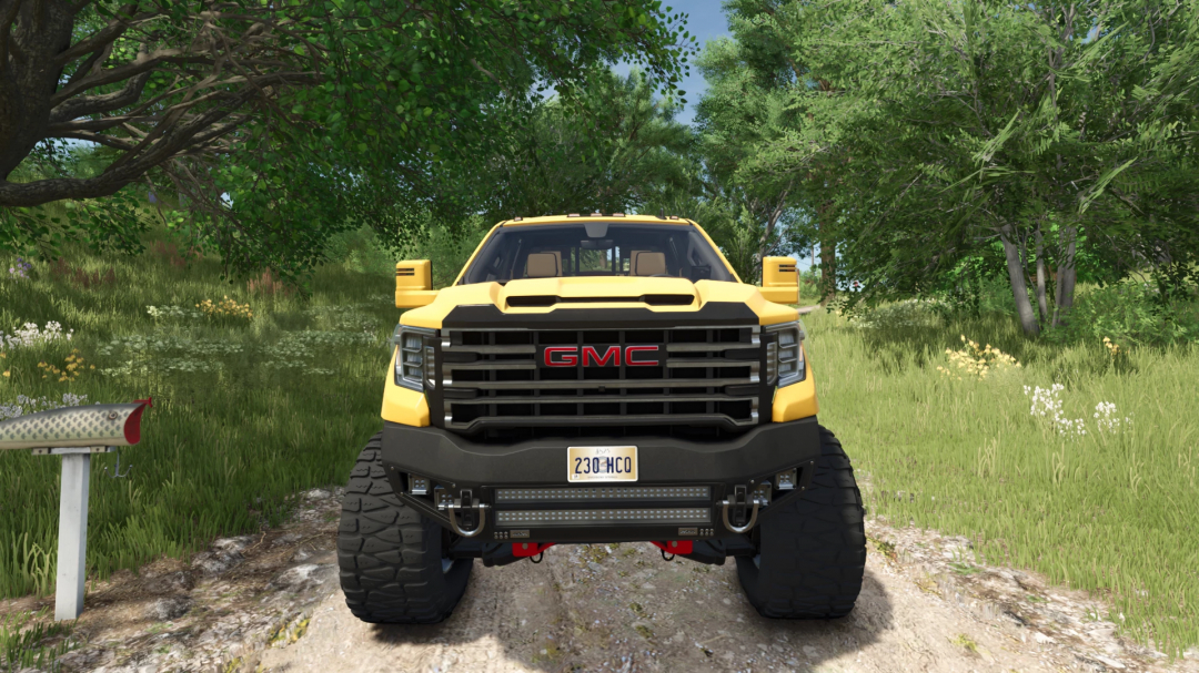 Front view of a yellow GMC Sierra Denali AT4 mod in FS25, set against a lush green landscape.