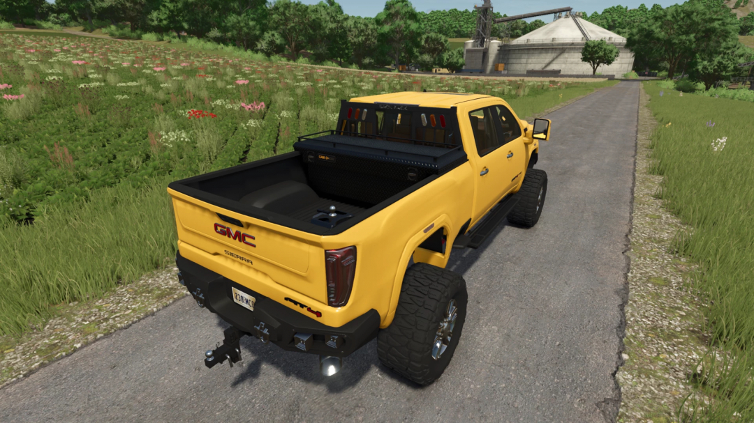 Yellow 2020 GMC Sierra Denali AT4 mod on a rural road in FS25.